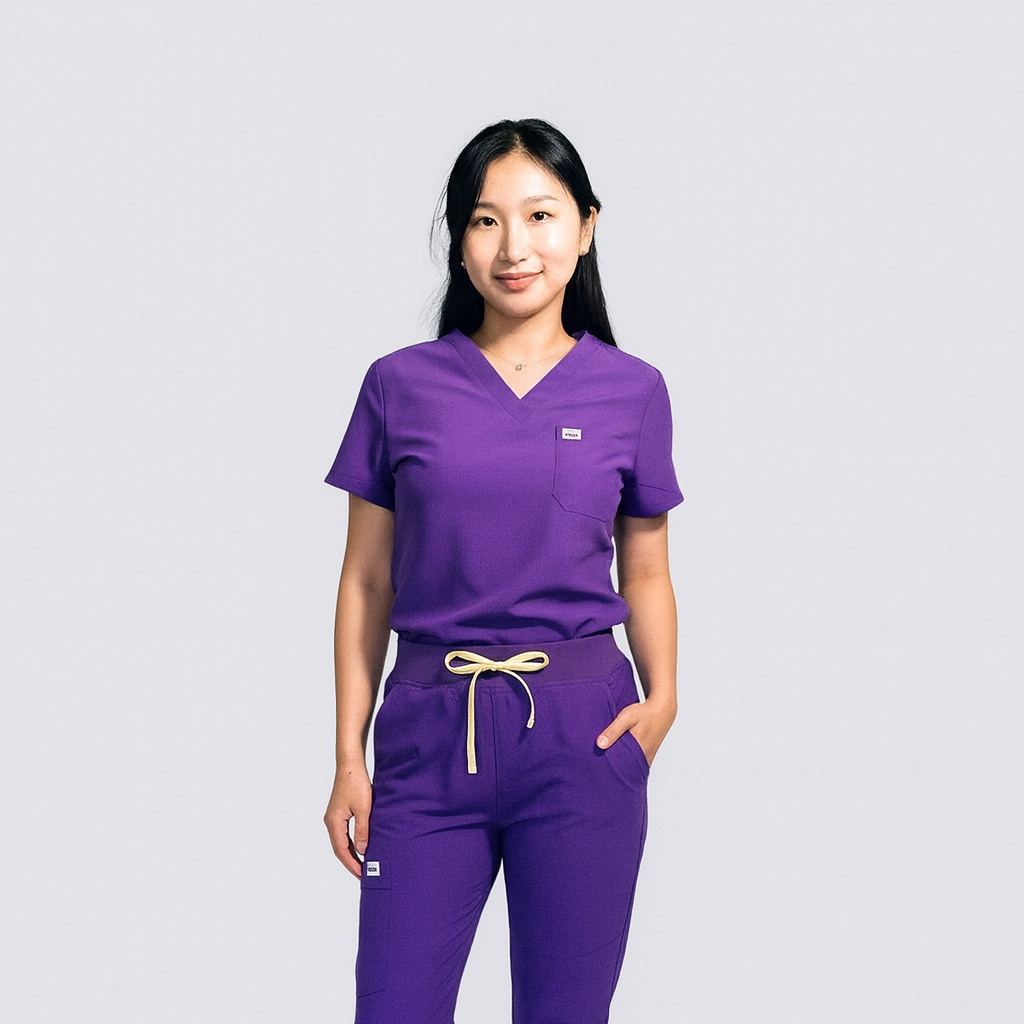 Person wearing a purple scrub set on a light gray background